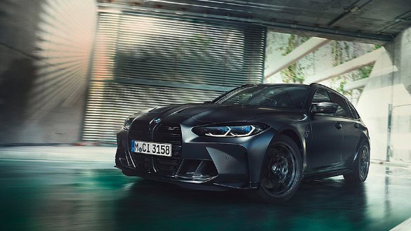 Schwarzer BMW fährt dynamisch in einer modernen Tiefgarage mit Betonwänden und Lichteffekten.