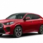 Roter BMW iX2 auf weißem Hintergrund, seitlich von vorne fotografiert.