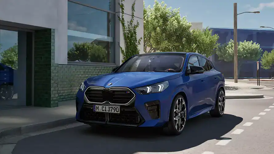 Blauer BMW SUV auf Stadtstraße, modernes Gebäude im Hintergrund, sonniges Wetter.