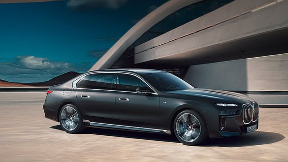 Dunkler BMW 7er vor modernem Gebäude bei Tageslicht.