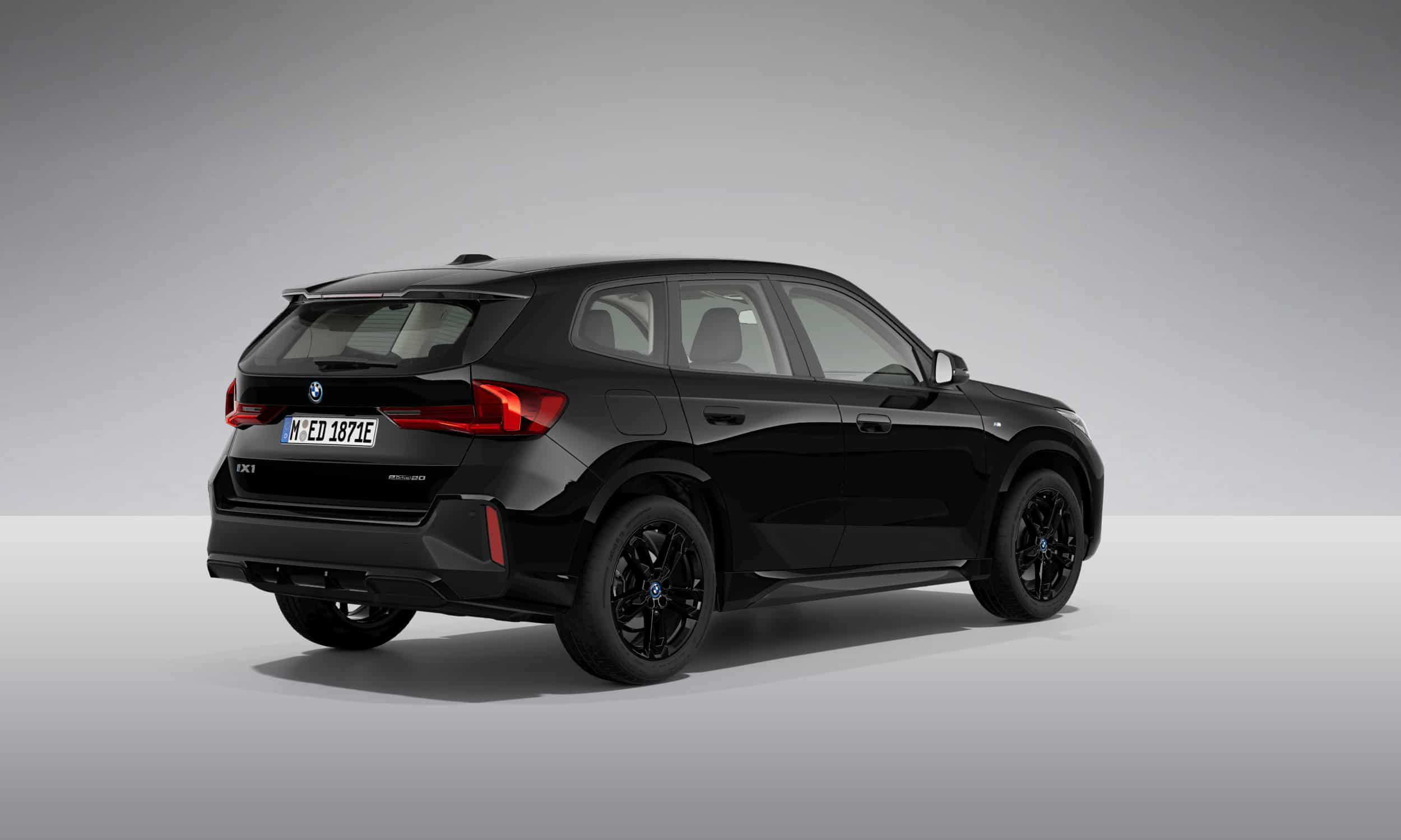 Schwarzer BMW iX1 von hinten, stehend auf grauem Hintergrund.
